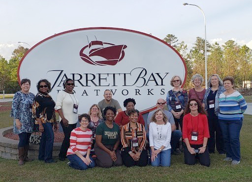 Photo of people in front of Jarrett Bay sign